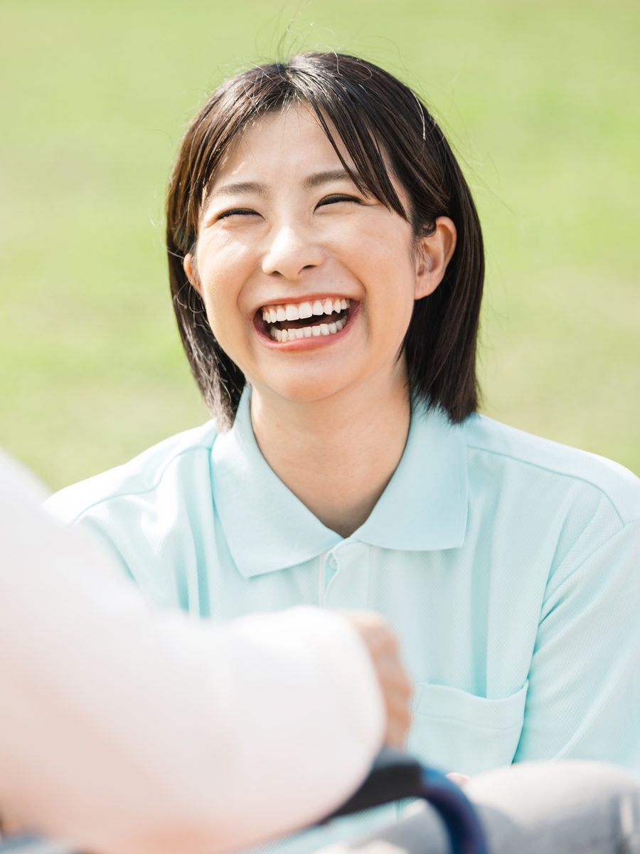 利用者さんと向き合い、楽しそうに笑うヘルパー