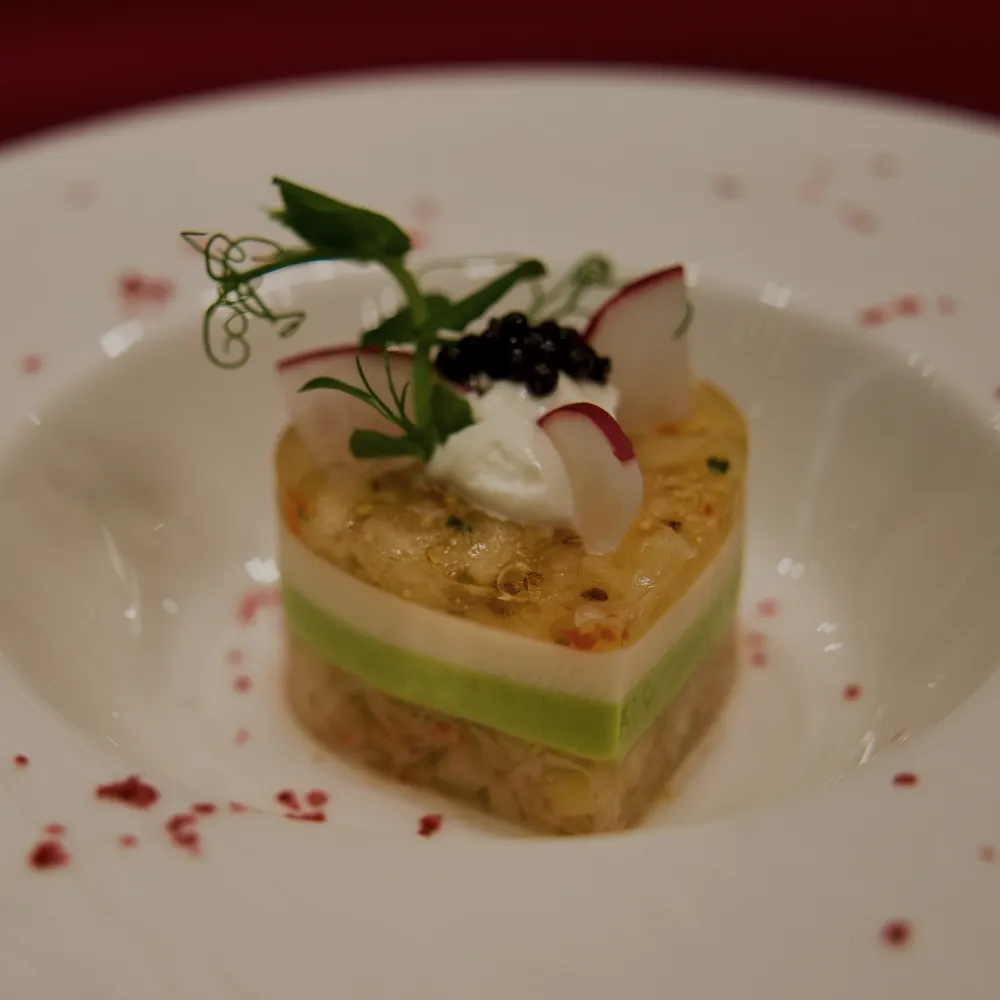 ハート形に重ねた前菜に、キャビアとラディッシュを添えた一皿